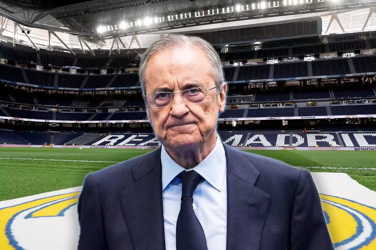 A man in a suit and tie is standing in an empty soccer stadium.