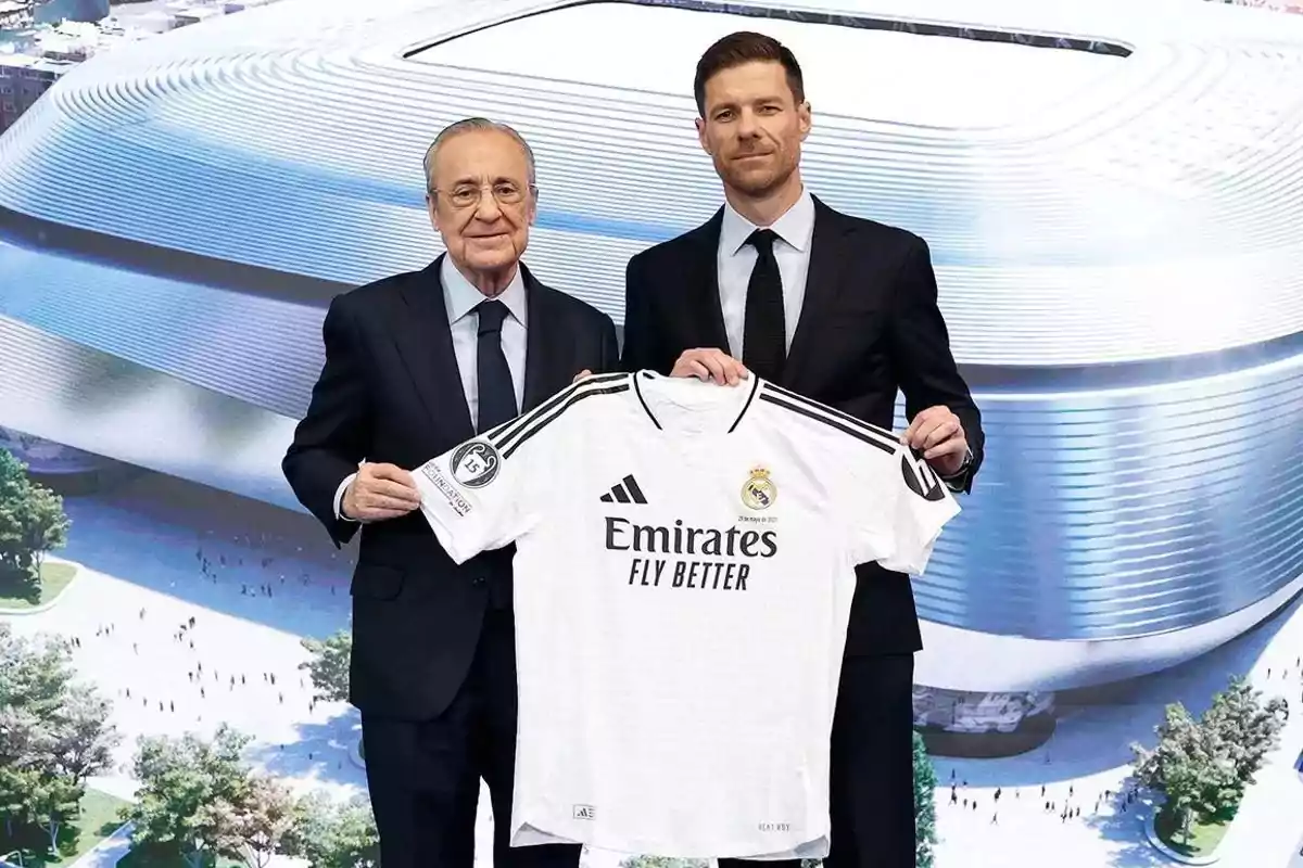 Dos hombres con traje sostienen una camiseta del Real Madrid frente a una imagen del estadio Santiago Bernabéu Dos hombres con traje sostienen una camiseta del Real Madrid frente a una imagen del estadio Santiago Bernabéu