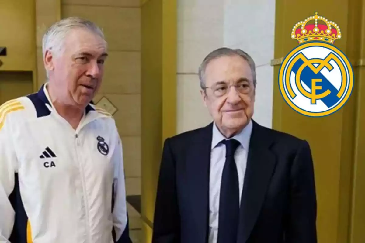 Dos hombres conversan en un edificio con el logo del Real Madrid en la pared.