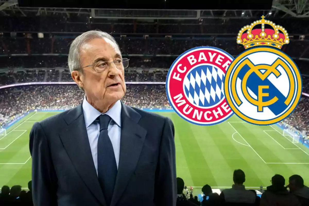 A man in a suit in a soccer stadium with the logos of FC Bayern Munich and Real Madrid in the background.