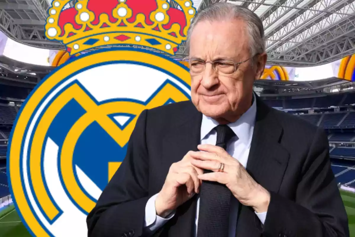 Un hombre de traje frente al escudo del Real Madrid en un estadio.