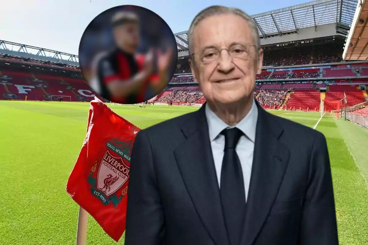 Un hombre con traje está frente a un estadio de fútbol con una bandera del Liverpool FC en primer plano y una imagen borrosa de un jugador en el fondo.