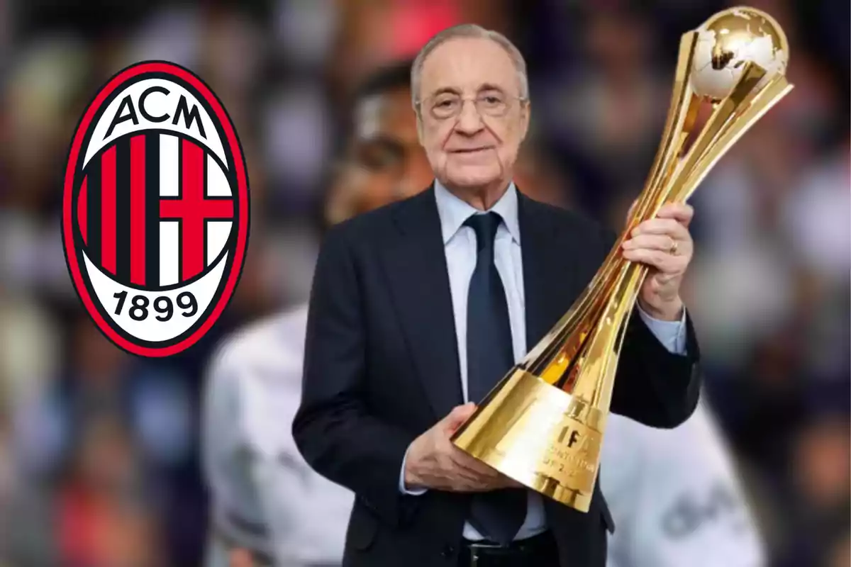 A man in a suit holds a golden trophy in front of the AC Milan logo.