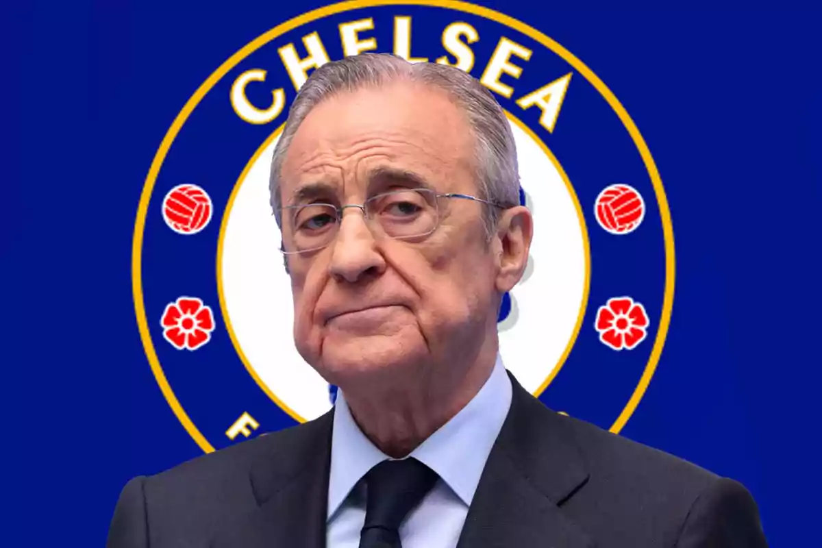 Un hombre mayor con gafas y traje frente a un logo de Chelsea FC.