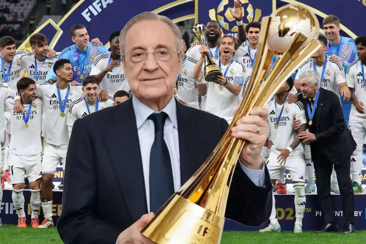 Un hombre sosteniendo un trofeo dorado frente a un grupo de jugadores de fútbol celebrando en el fondo.