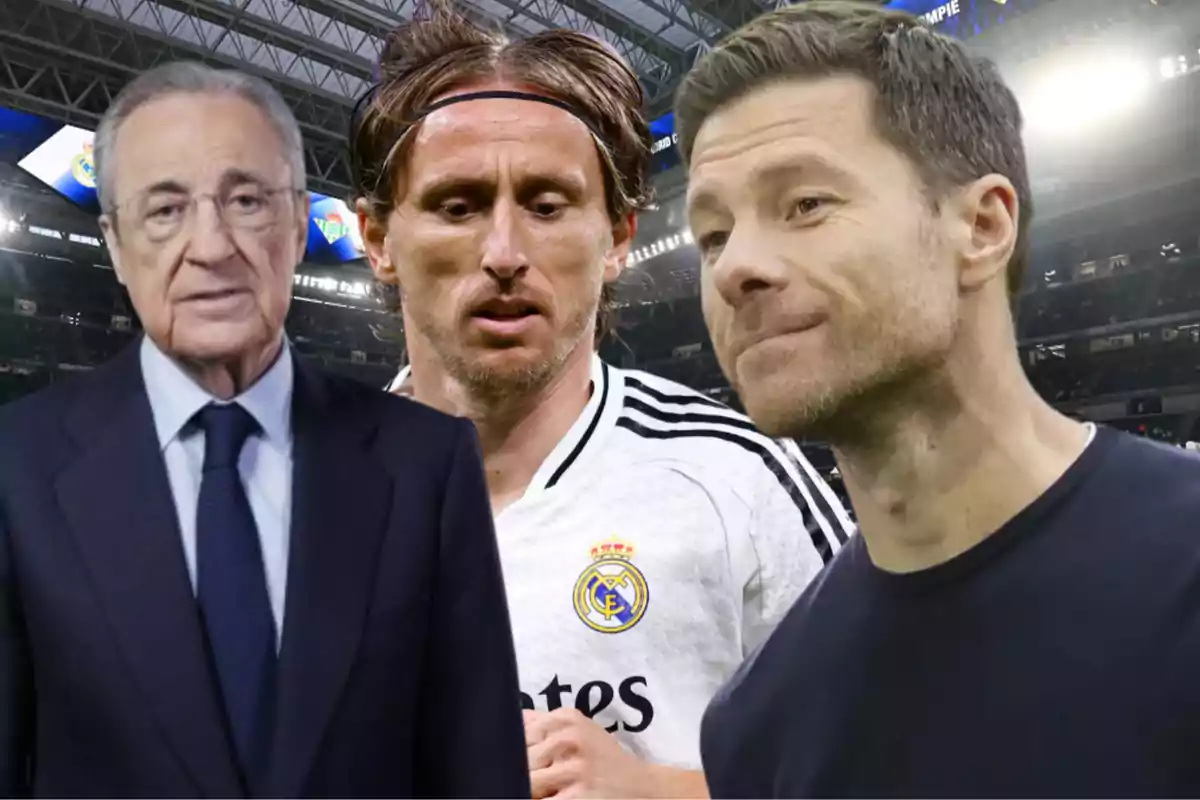 Three men in a soccer stadium, one of them is wearing a suit, another a white soccer jersey, and the third a dark jersey.
