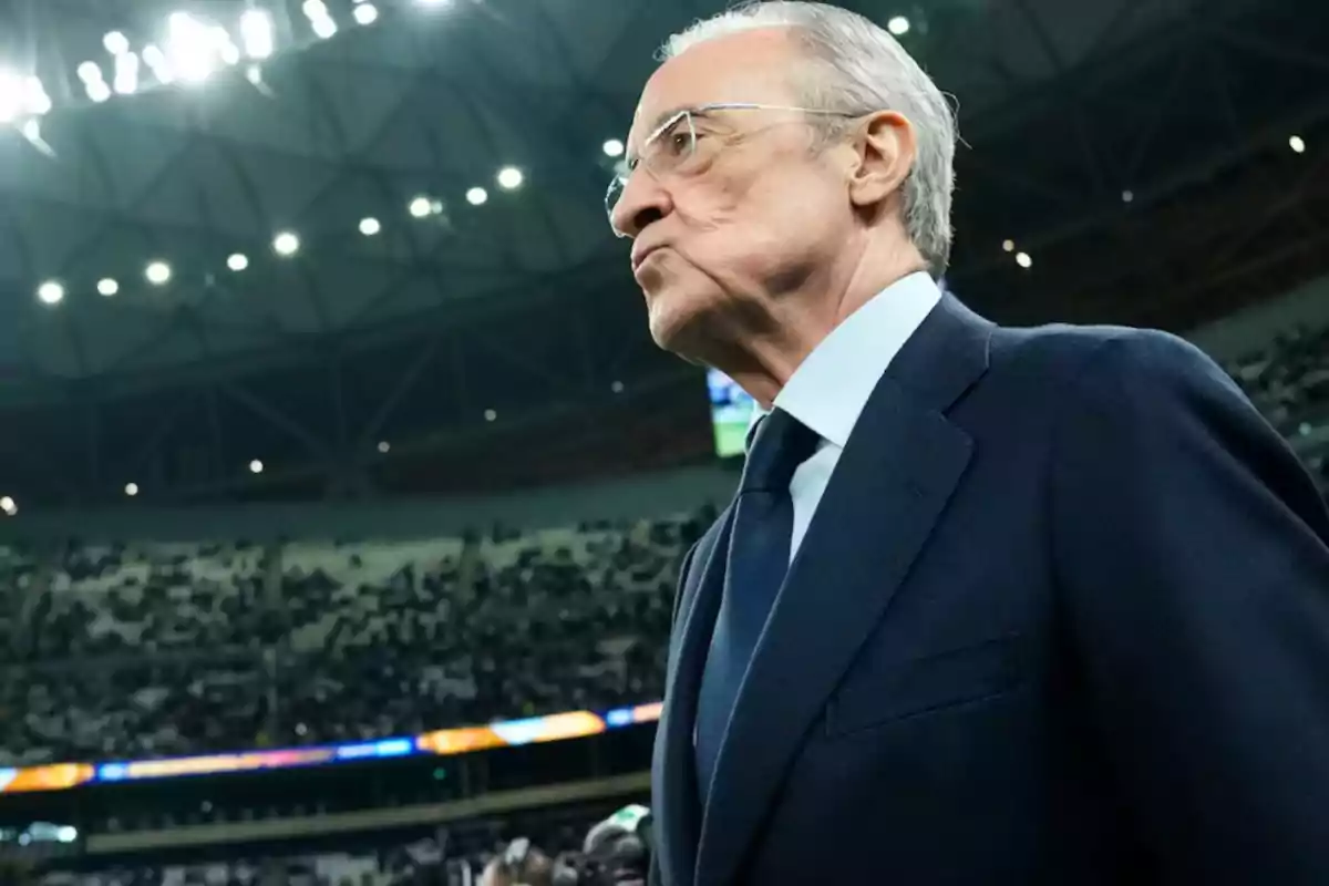 A man in a suit in a lit stadium.