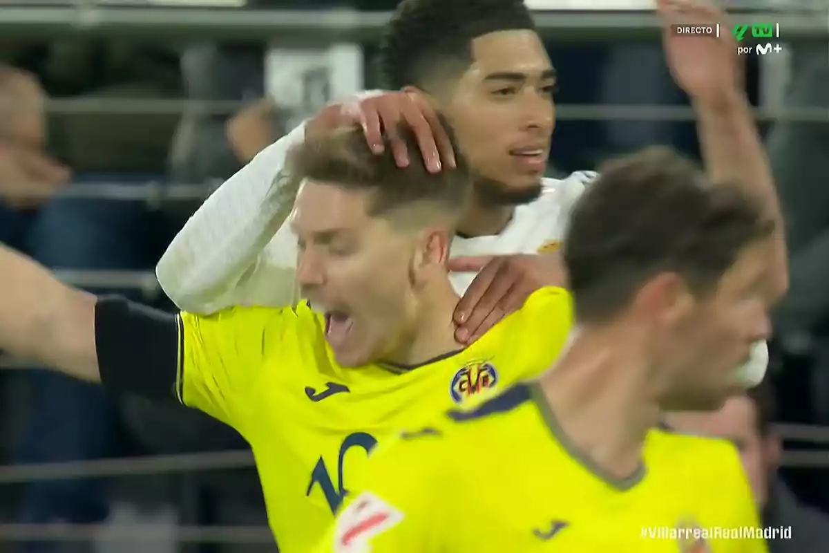 A player in a yellow jersey appears to be celebrating while another player holds him by the shoulders during a match. A player in a yellow jersey appears to be celebrating while another player holds him by the shoulders during a match.