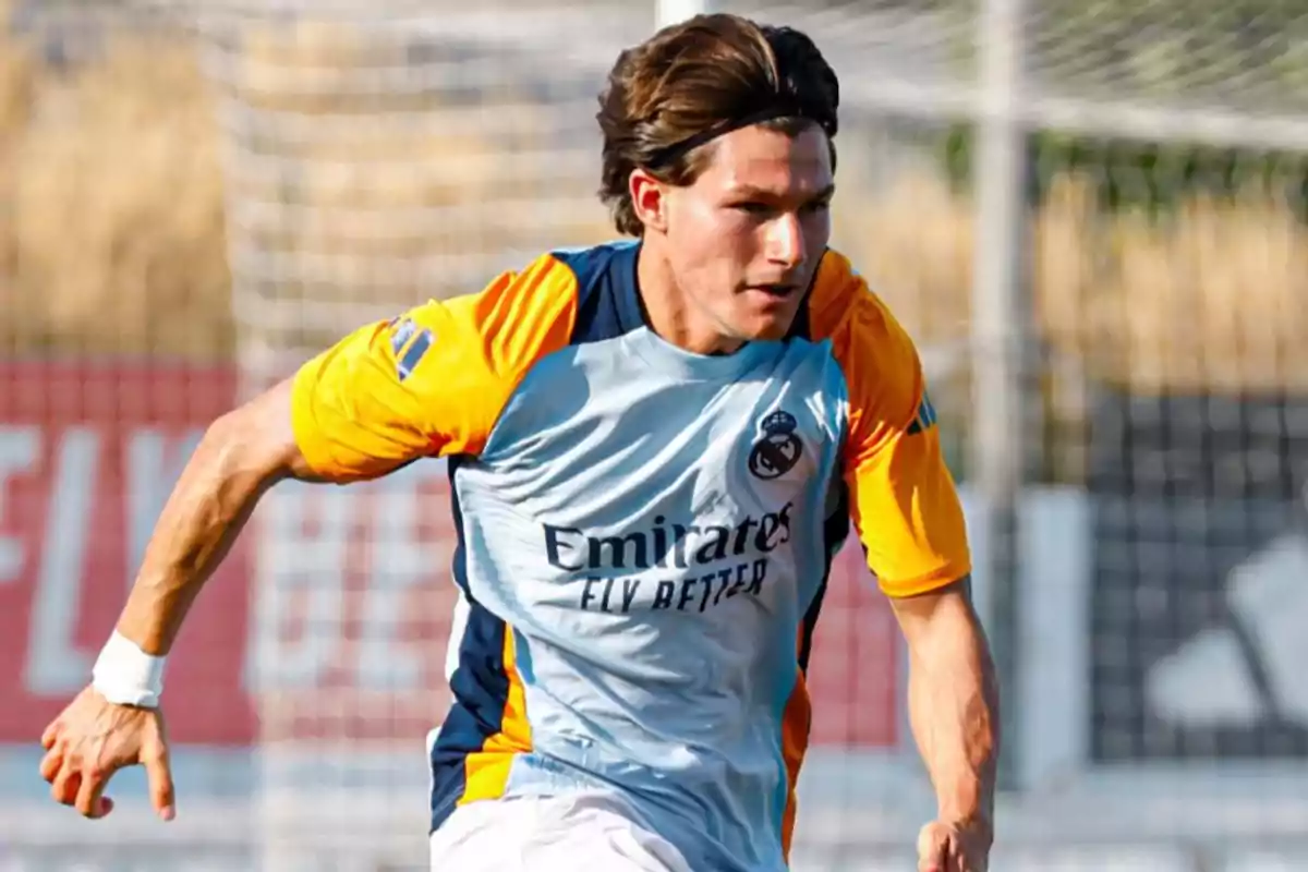 Jugador de fútbol corriendo en el campo con uniforme de entrenamiento del Real Madrid. Jugador de fútbol corriendo en el campo con uniforme de entrenamiento del Real Madrid.
