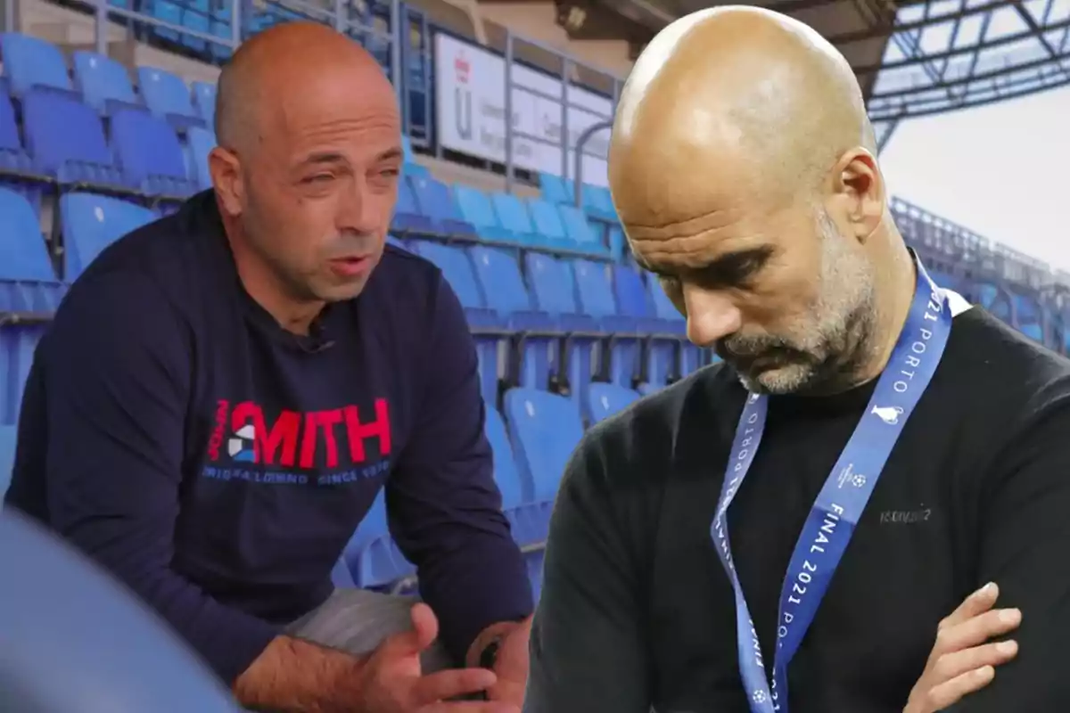 Two bald men in a stadium, one is sitting and talking, the other is standing with a medal and his head tilted.