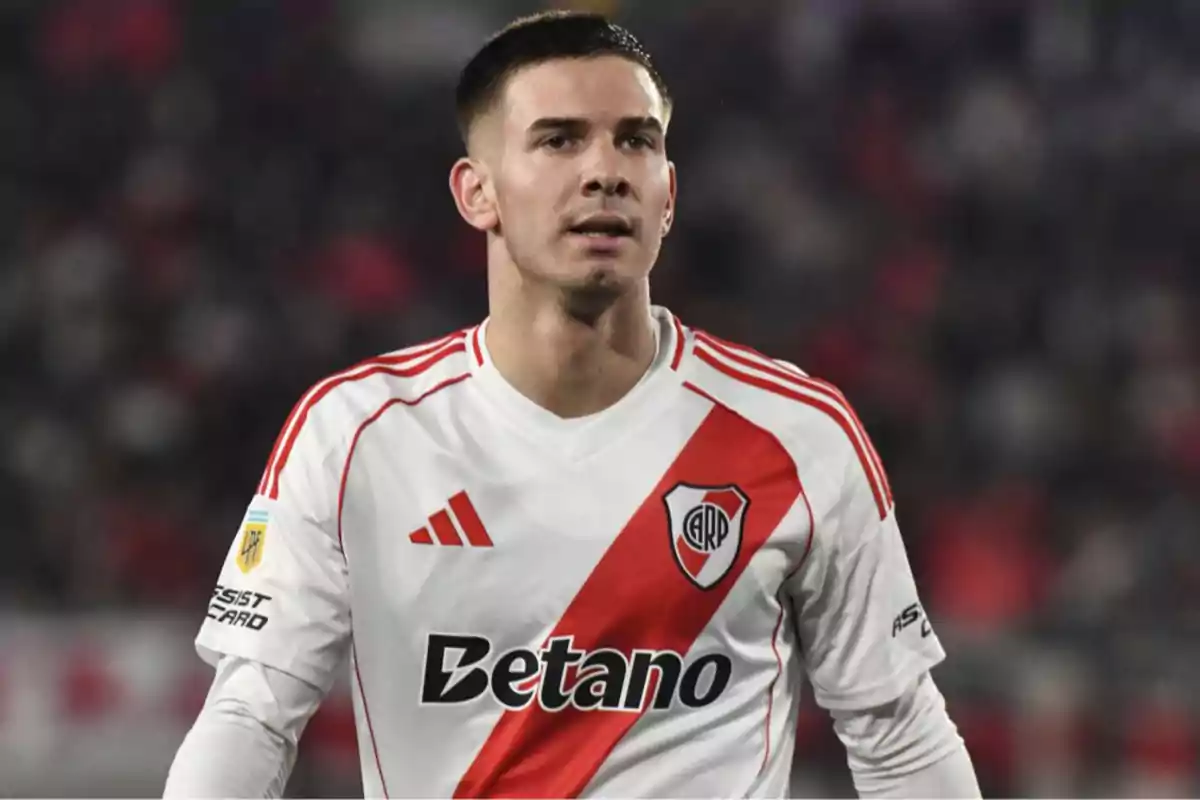 Soccer player wearing a white uniform with a red River Plate sash in a stadium Soccer player wearing a white uniform with a red River Plate sash in a stadium