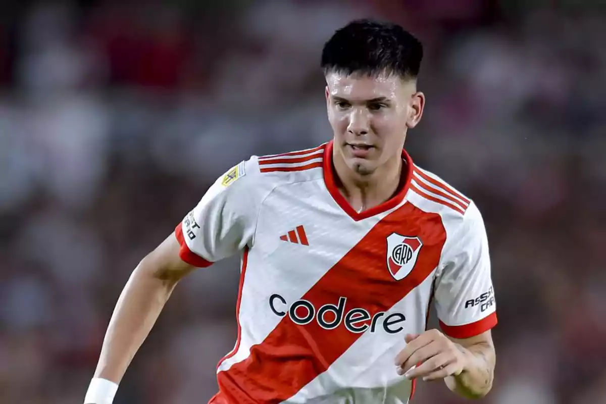 Un jugador de fútbol con el uniforme de River Plate en acción durante un partido.