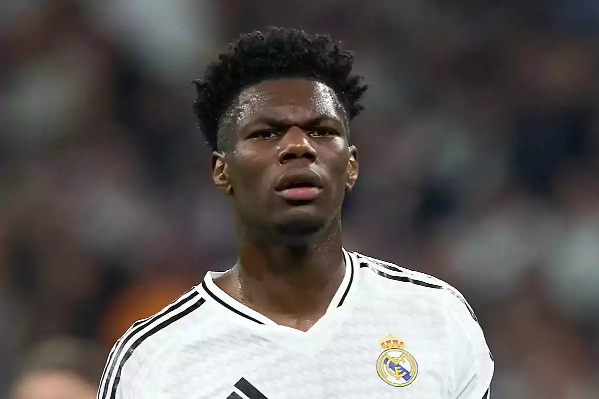 Un jugador de fútbol con el uniforme blanco del Real Madrid en el campo de juego. Un jugador de fútbol con el uniforme blanco del Real Madrid en el campo de juego.