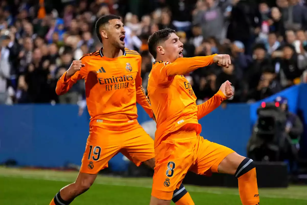 Jugadores del Real Madrid celebrando un gol en el campo con uniformes naranjas. Jugadores del Real Madrid celebrando un gol en el campo con uniformes naranjas.