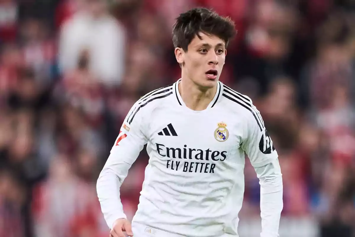 Soccer player in a white Real Madrid uniform on the field.