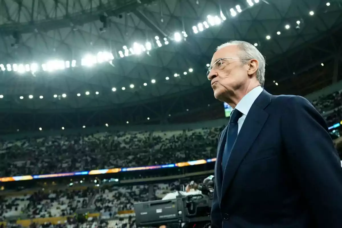 Un hombre de traje en un estadio lleno de espectadores.