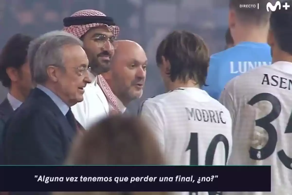 A group of people, some wearing soccer jerseys, chat at a sporting event. A group of people, some wearing soccer jerseys, chat at a sporting event.