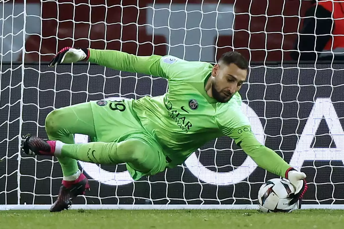 Goalkeeper in a green uniform stopping a ball during a soccer match in front of the goal Goalkeeper in a green uniform stopping a ball during a soccer match in front of the goal