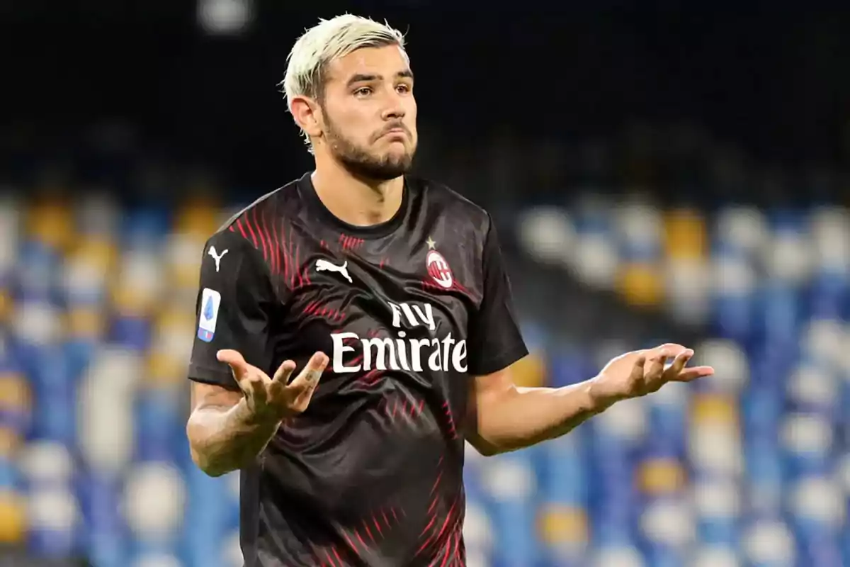 Un jugador de fútbol con camiseta negra gesticula con las manos en un estadio. Un jugador de fútbol con camiseta negra gesticula con las manos en un estadio.