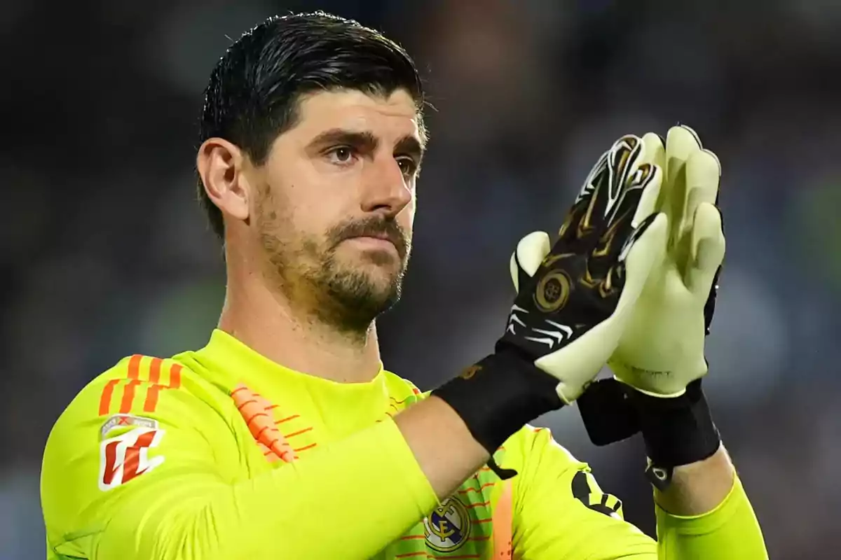 A soccer goalkeeper in a yellow uniform clapping on the field. A soccer goalkeeper in a yellow uniform clapping on the field.