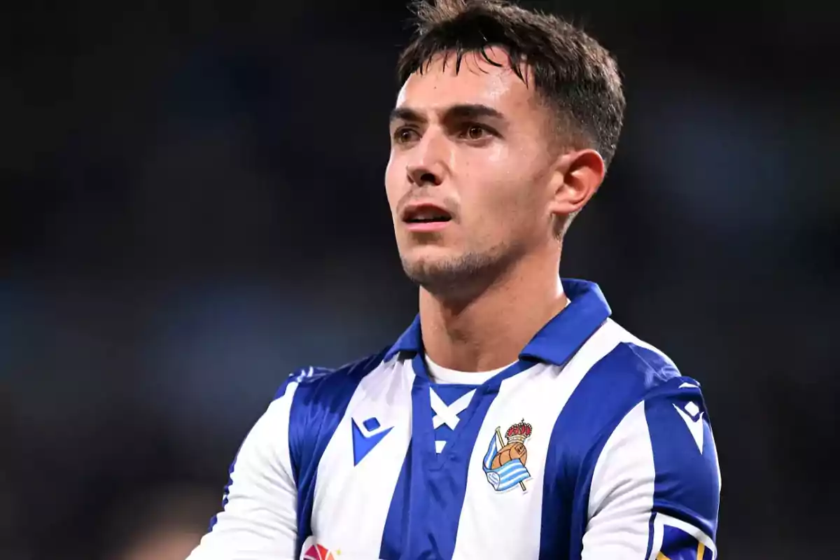 Football player in blue and white Real Sociedad uniform on the field.