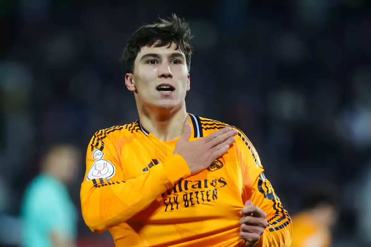 Soccer player in an orange uniform celebrating on the field during a match Soccer player in an orange uniform celebrating on the field during a match