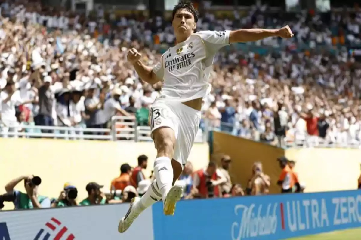 Futbolista del Real Madrid celebrando un gol con un salto frente a una multitud en el estadio Futbolista del Real Madrid celebrando un gol con un salto frente a una multitud en el estadio