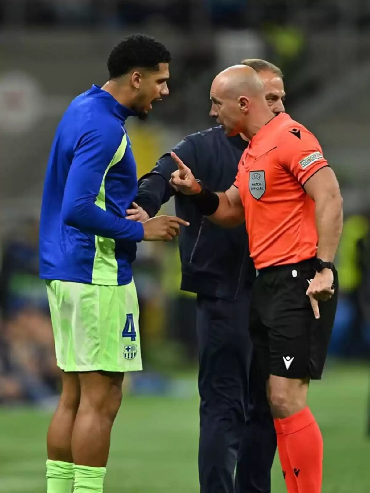 Un jugador de fútbol discute con un árbitro en el campo durante un partido. Un jugador de fútbol discute con un árbitro en el campo durante un partido.