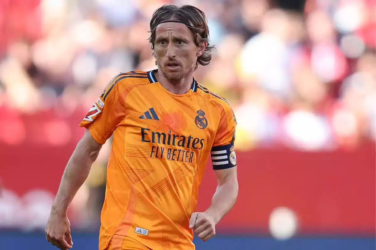 Soccer player in an orange Real Madrid uniform on the field. Soccer player in an orange Real Madrid uniform on the field.