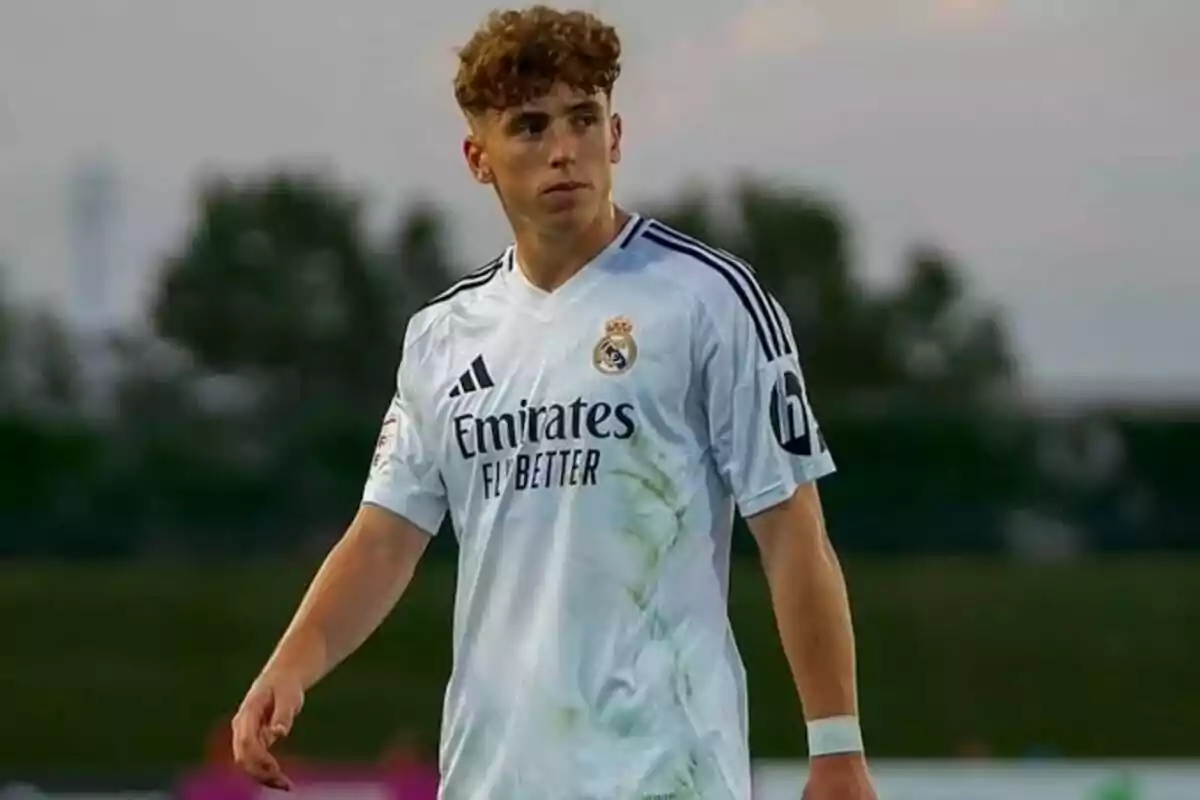 Joven futbolista con uniforme blanco del Real Madrid en un campo de juego al aire libre Joven futbolista con uniforme blanco del Real Madrid en un campo de juego al aire libre