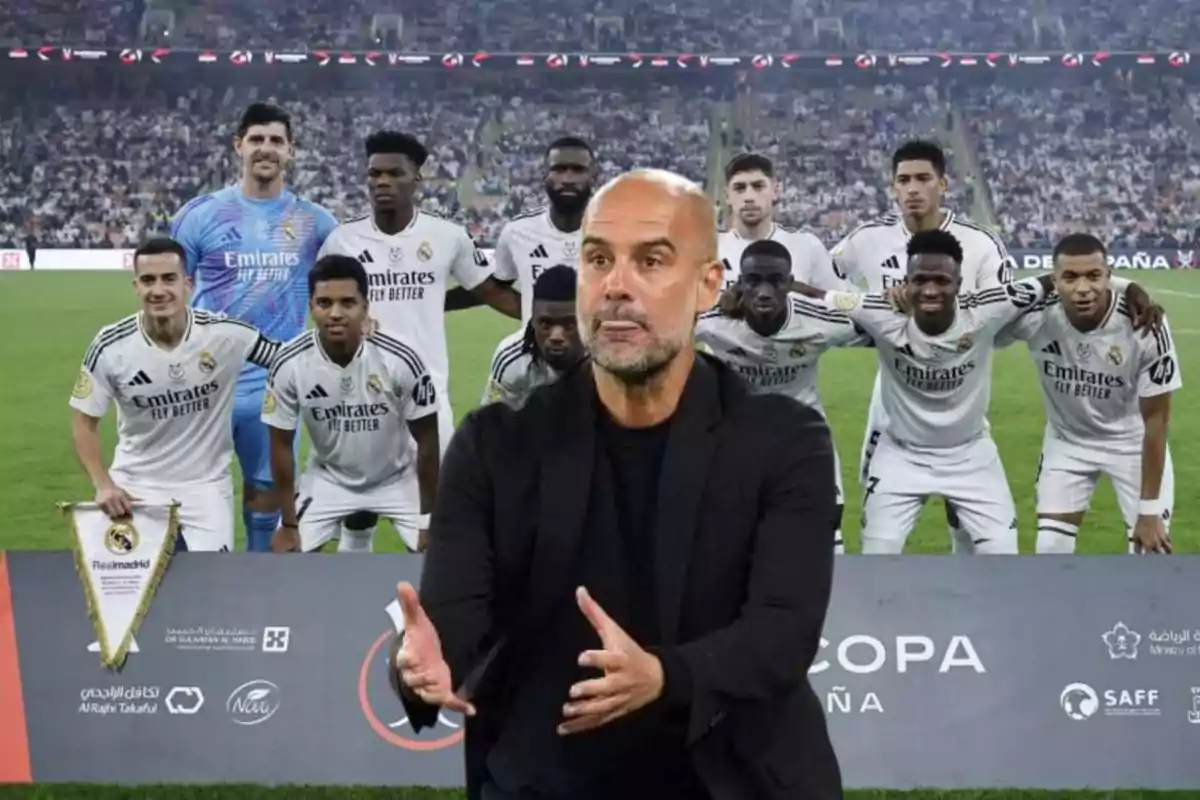 Un entrenador de fútbol gesticula frente a un equipo posando en el campo.