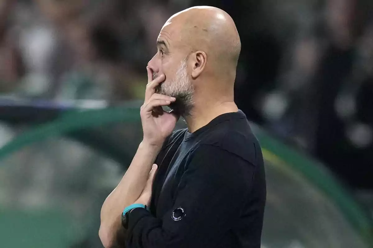Pensive bald man with beard with hand on face dressed in black in a sports environment. Pensive bald man with beard with hand on face dressed in black in a sports environment.