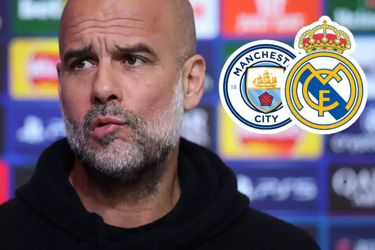 Un hombre en una conferencia de prensa con los logos de Manchester City y Real Madrid al fondo.