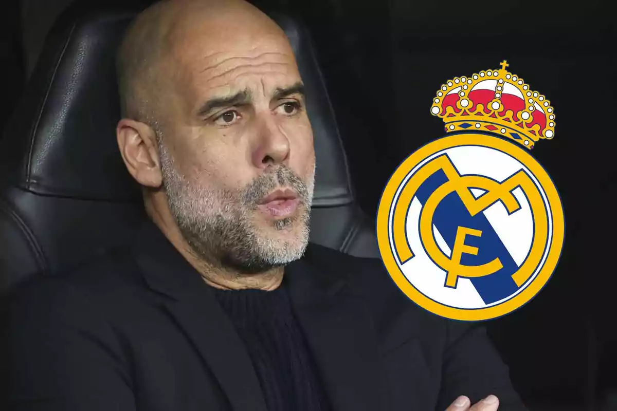 Un hombre calvo con barba sentado en un asiento negro junto al escudo del Real Madrid.