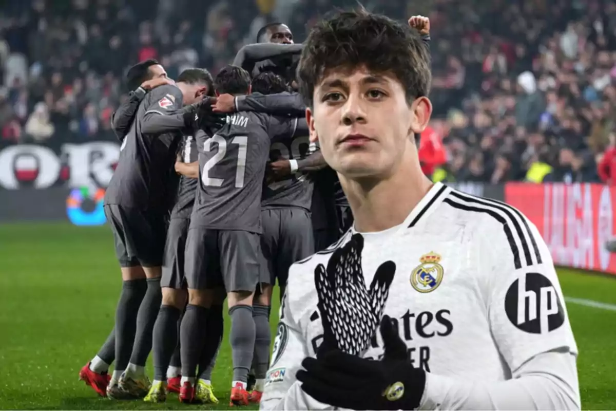 Un jugador de fútbol con uniforme blanco del Real Madrid en primer plano y un grupo de jugadores celebrando en el fondo.