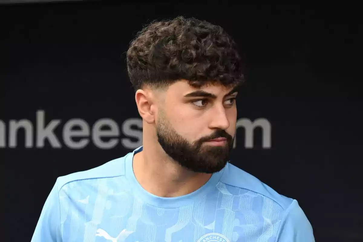 A man with a beard and curly hair is wearing a light blue T-jersey. A man with a beard and curly hair is wearing a light blue T-jersey.