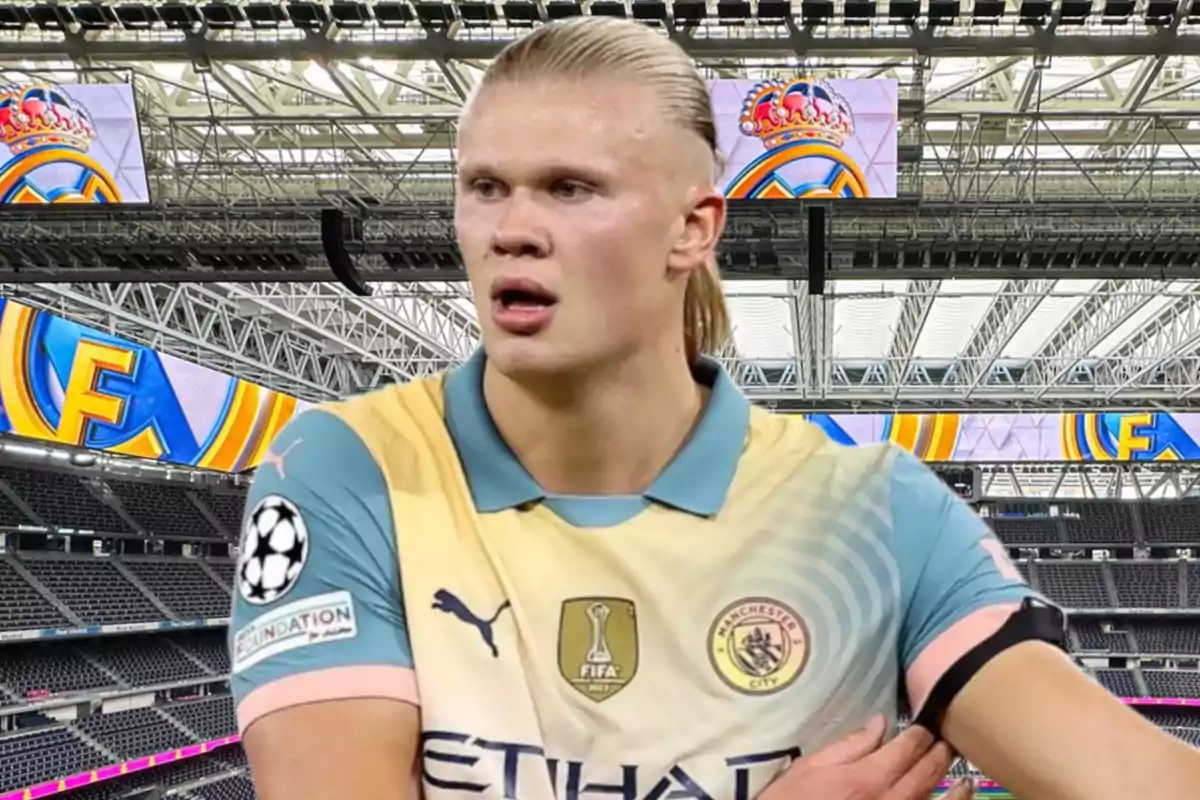 A soccer player in a Manchester City uniform in a stadium with screens displaying the Real Madrid crest.