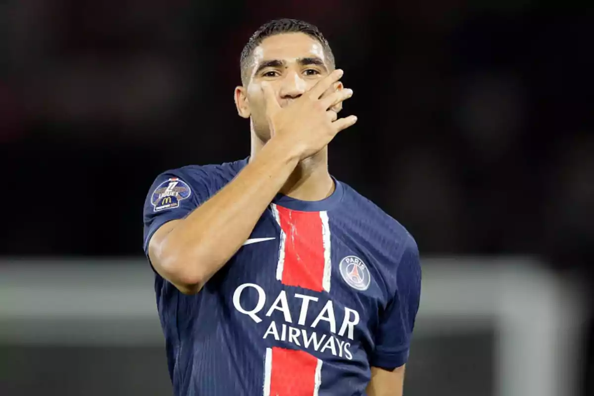 Football player in PSG uniform celebrating on the field. Football player in PSG uniform celebrating on the field.