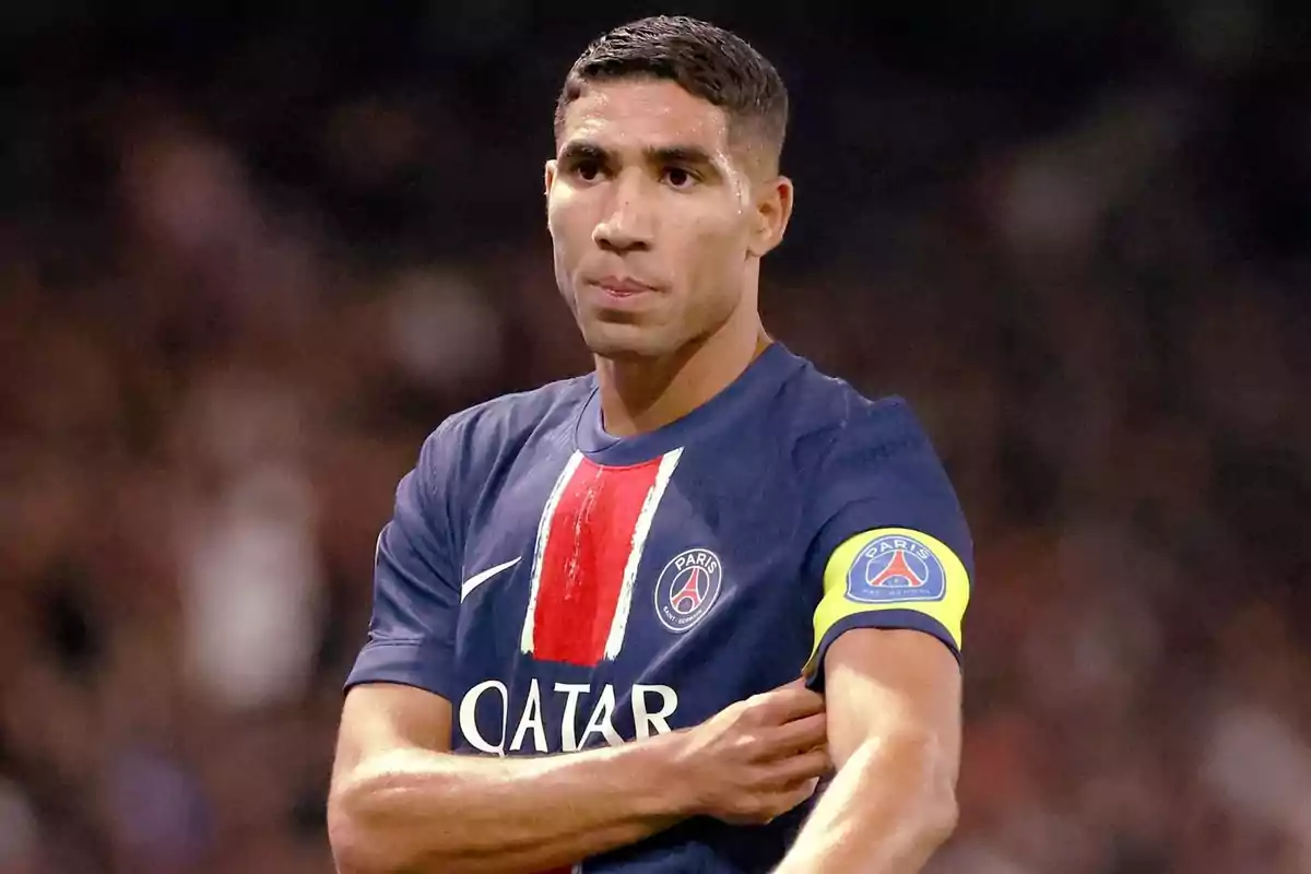 Football player in PSG uniform and captain's armband on the field. Football player in PSG uniform and captain's armband on the field.