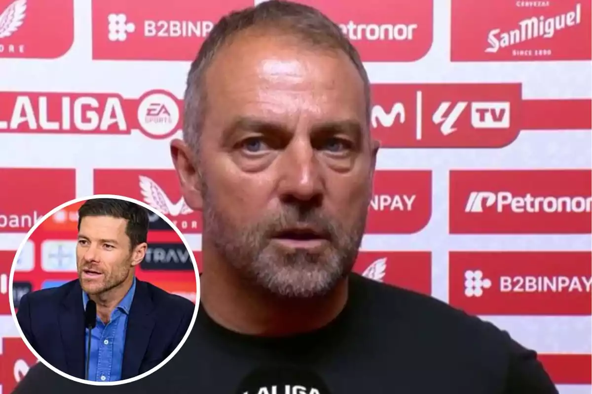 A man with short hair and a beard is giving an interview in front of a background with sports sponsor logos, and in the lower left corner there is a box showing another man speaking at a press conference.