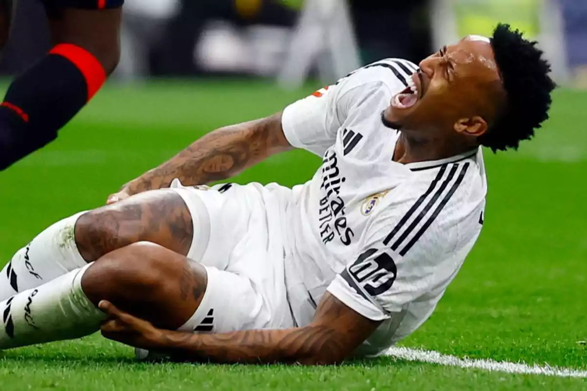 Soccer player on the ground with pain expression during a match.