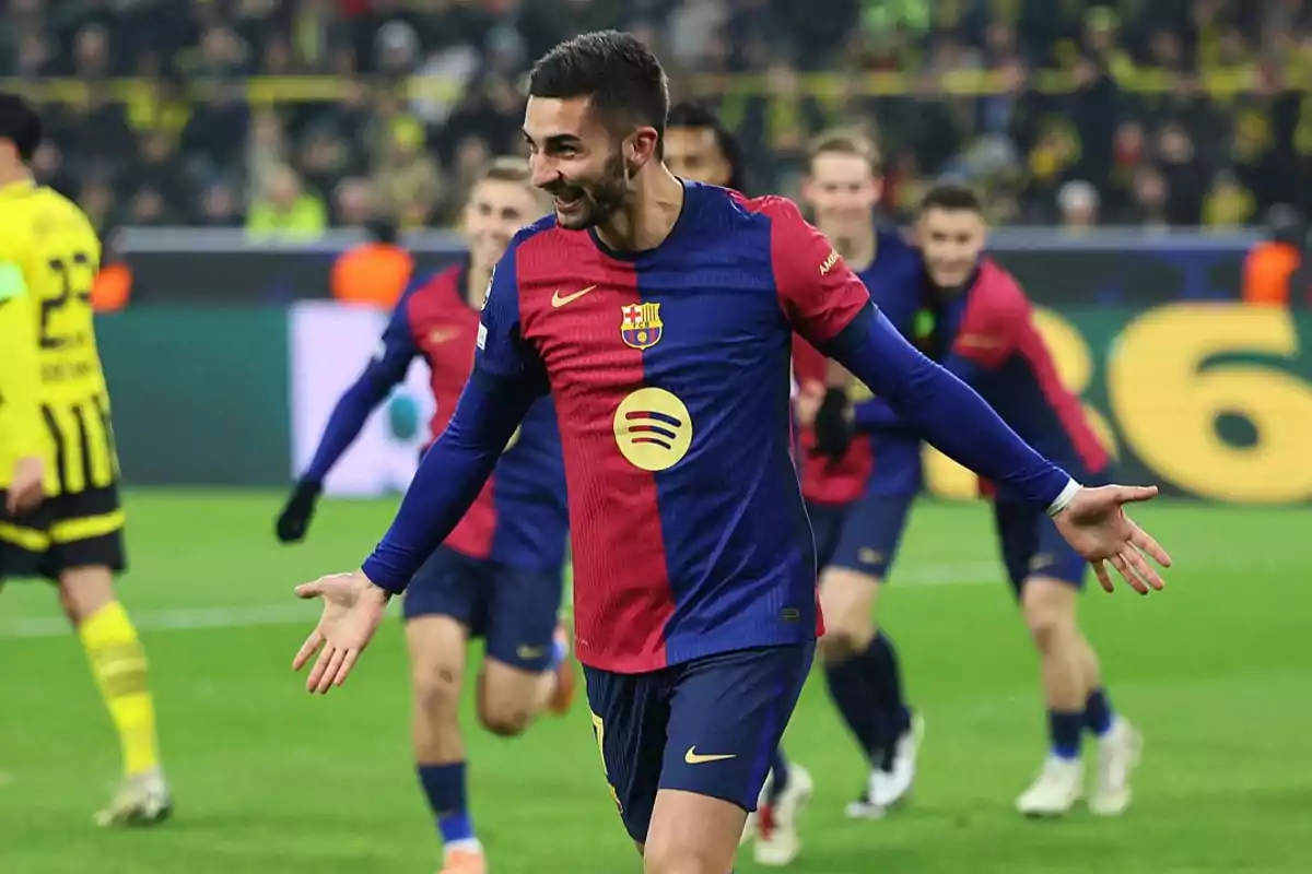 Soccer player celebrating a goal in a match in blue and red uniform.