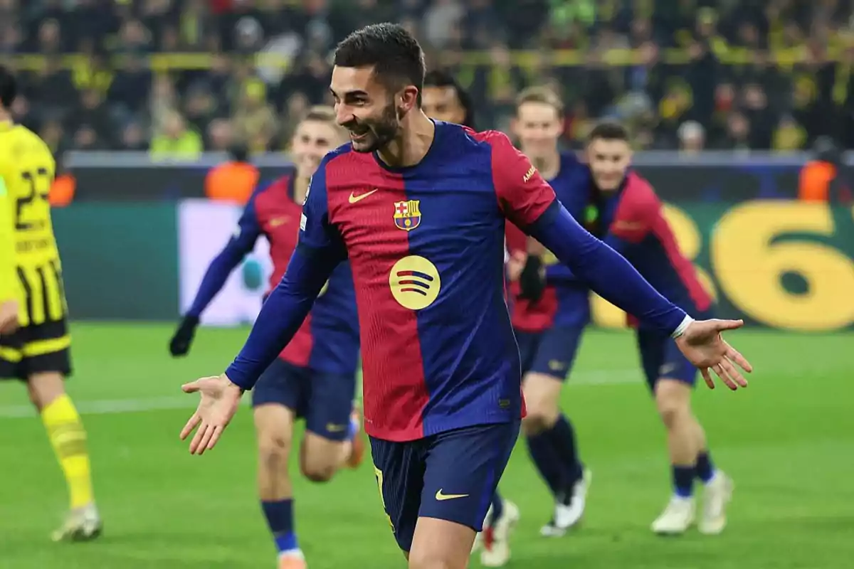 Soccer player celebrating a goal in a match in blue and red uniform.