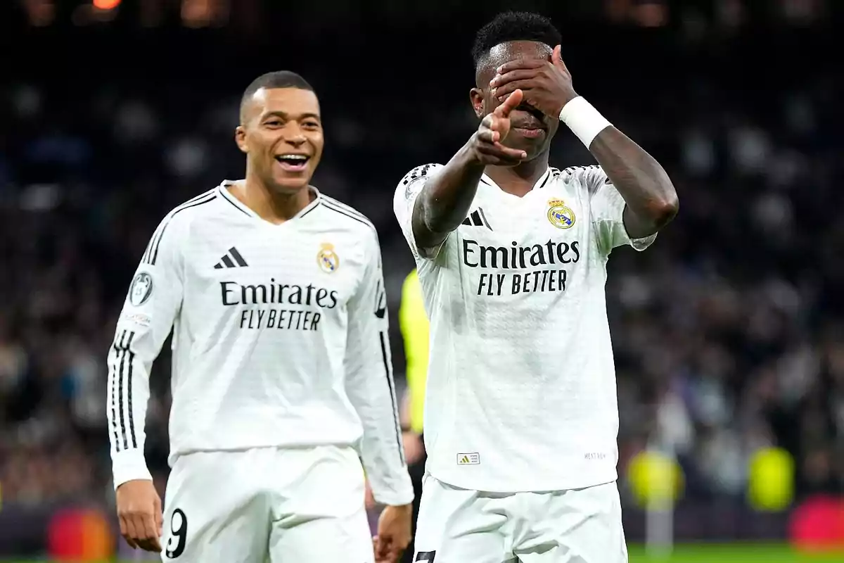 Two Real Madrid players celebrate on the field with smiles and gestures of joy. Two Real Madrid players celebrate on the field with smiles and gestures of joy.