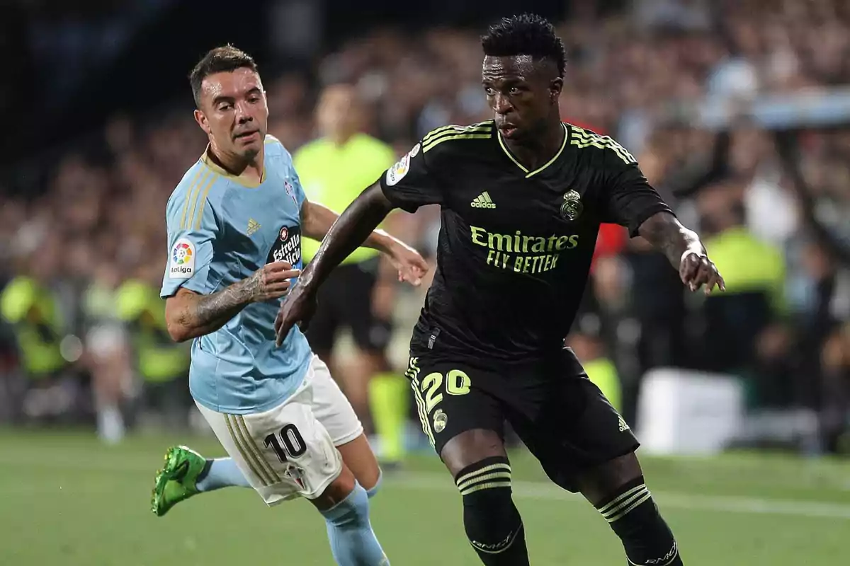Two players compete for the ball in a match, one wearing light blue and the other black. Two players compete for the ball in a match, one wearing light blue and the other black.