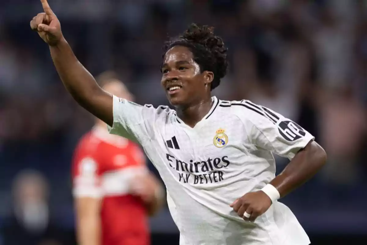 Soccer player in white uniform celebrating a goal with his arm raised. Soccer player in white uniform celebrating a goal with his arm raised.