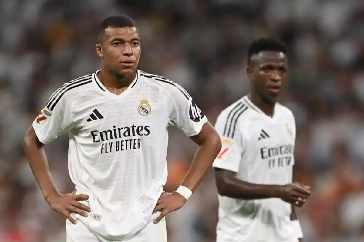 Soccer players in white uniforms on the field during a match.