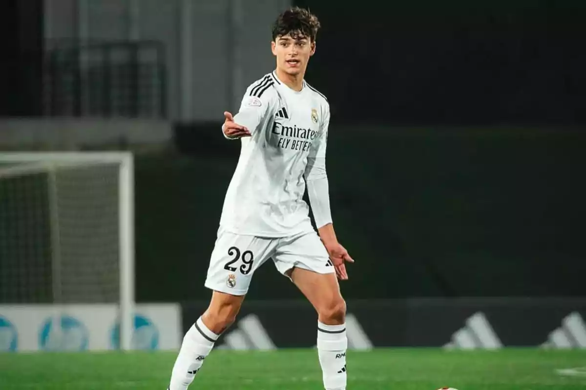 Soccer player in a white Real Madrid uniform on the field during a match pointing with his hand