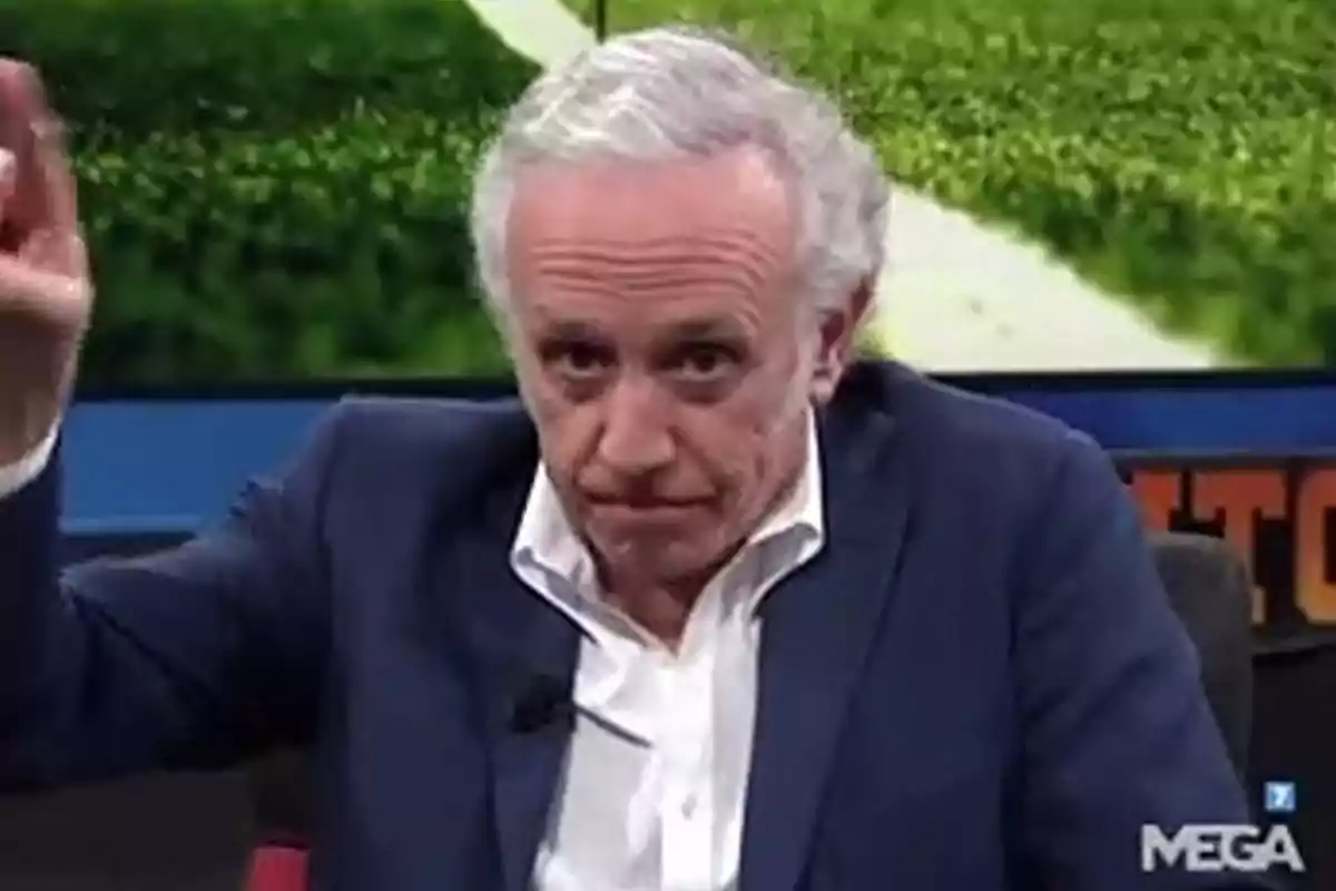 Hombre de cabello canoso con expresión seria levantando la mano en un set de televisión Hombre de cabello canoso con expresión seria levantando la mano en un set de televisión