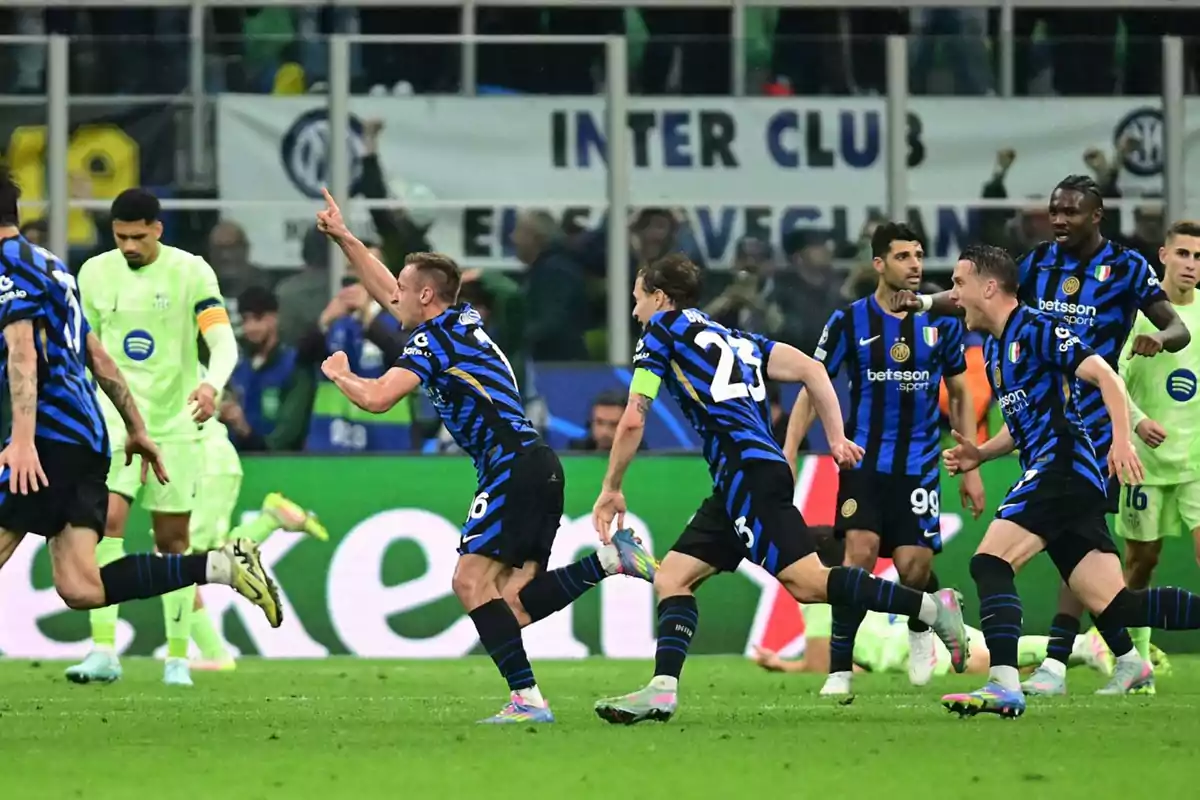 Soccer players celebrate a goal in a match while other players watch on the field. Soccer players celebrate a goal in a match while other players watch on the field.
